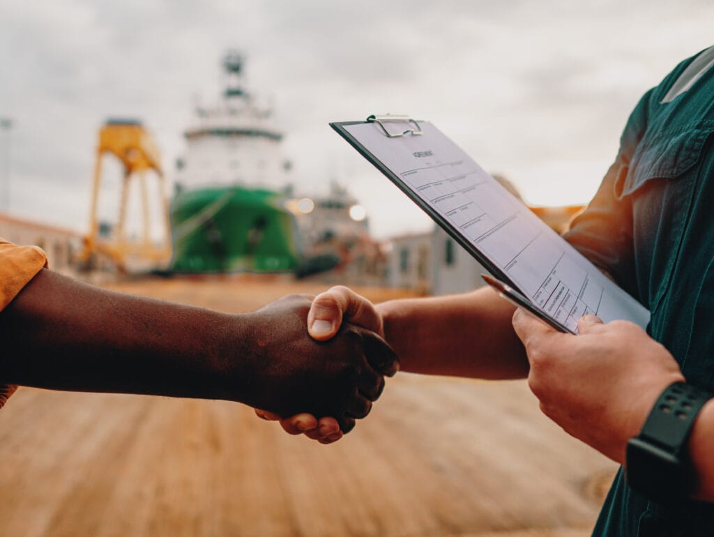 marine contractor businessman handshaking with worker on the ship